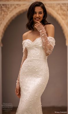 a woman in a wedding dress posing for the camera with her hand on her face