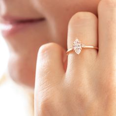 a woman's hand with a diamond ring on it