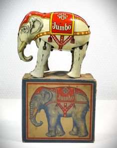 an elephant figurine is sitting on top of a box with the word jumbo painted on it