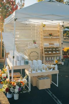 an outdoor market with white tents and flowers