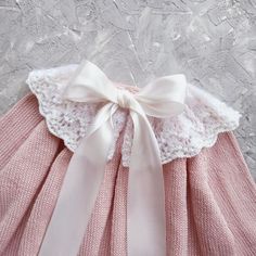 a pink dress with a white bow on it