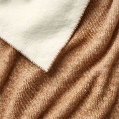 the fabric is brown and white with a small patch in it's center, on top of a beige blanket