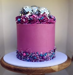 a purple cake with disco balls on top