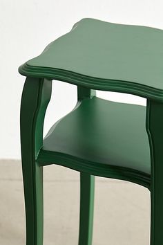 a small green table with two shelves on each side