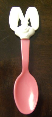 a pink spoon with a white face on it