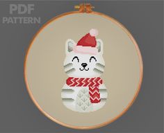 a cross stitch pattern with a cat wearing a santa hat and scarf