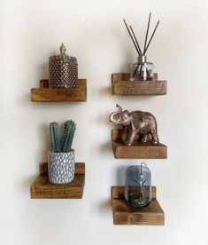 three wooden shelves with decorative items on them, one elephant and the other an elephant