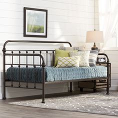 a metal bed frame with a blue blanket on it