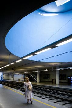 a woman is walking down the train tracks