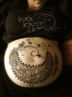 a pregnant belly with an intricate design on it