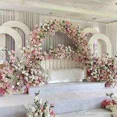 a white and pink wedding stage with flowers on it