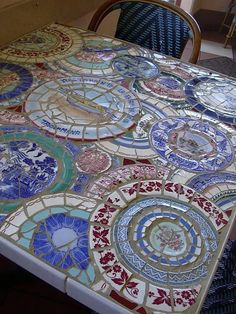 a table topped with lots of plates covered in different colors and designs on top of it