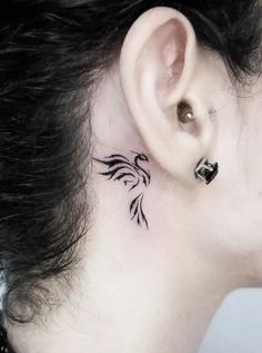 a woman's ear with a small tattoo on it