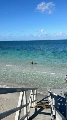 people are swimming in the ocean on a sunny day