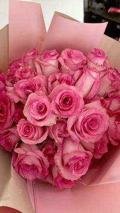 a bouquet of pink roses in a paper box