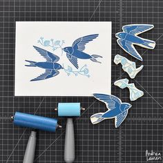 some blue birds are sitting on top of a piece of paper next to cricut markers