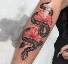 a snake and flower tattoo on the arm