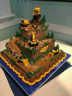 a three tiered cake is decorated with construction equipment