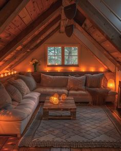 a living room filled with lots of furniture under a lofted ceiling covered in lights