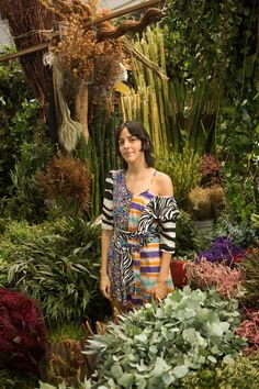 a woman is standing in the middle of some plants