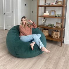 a woman sitting on a bean bag chair in the living room with her legs crossed