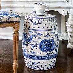 a blue and white vase sitting on top of a wooden floor next to a chair