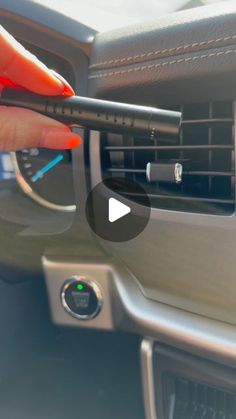 a person is adjusting the air conditioner on a car's dashboard with an arrow pointing to it