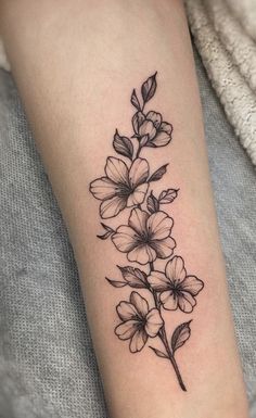 a black and white flower tattoo on the arm