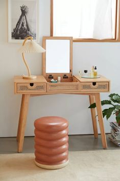 a desk with a mirror, lamp and other items on it