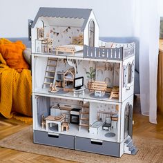 a doll house made out of cardboard with furniture and accessories on the top floor in front of a couch