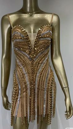 a mannequin with gold and silver chains on it's body, wearing a dress