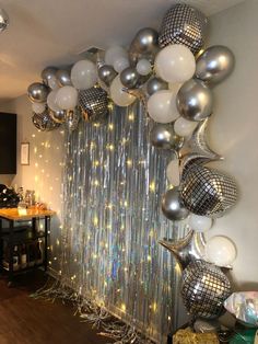 a room filled with lots of silver and white balloons