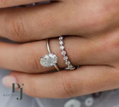 a woman's hand with a diamond ring on her finger and an engagement band