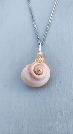 a necklace with a shell hanging from it's side