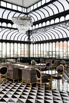 a dining room with black and white checkered flooring, chandelier and windows