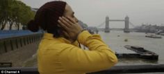 a woman wearing a yellow jacket is talking on her cell phone while looking at the water