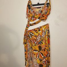 a dress hanging up on a wall next to a hanger with an object in it