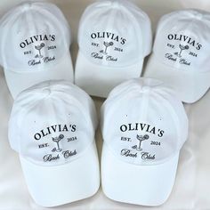 six white hats with the names of five different wineries on them, all in black and white