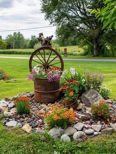 a garden with flowers, rocks and an old wagon