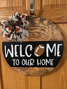 a door hanger that says welcome to our home with an american football on it