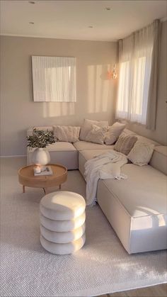 a living room filled with lots of white furniture and decor on top of carpeted flooring