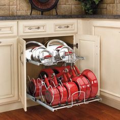 the kitchen space saver is open to show red pots and pans