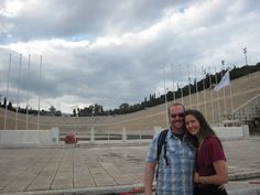 a man and woman standing next to each other in front of an empty amphit