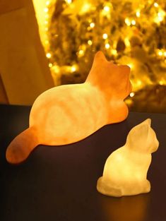 two plastic cats sitting next to each other on a table