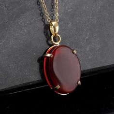 This necklace features an oval-shaped Yemeni agate stone. Yemen aqeeq stones are red and have unique patterns. Each stone is authentic and high quality. The pendant is delicately crafted and set in a 14ct plated case on high-quality sterling silver. The combination of the red agate stone and the eye-catching colour of the gold makes this necklace a true statement piece. This unisex vintage gemstone pendant is a versatile accessory that can be worn by both men and women. Are you looking for a truly unique and special piece of jewelry? Look no further than handmade necklaces! Our Handmade necklaces are crafted by skilled artisans who put their time, passion, and creativity into each piece they make. Unlike mass-produced necklaces, handmade necklaces are one-of-a-kind and have a certain chara Oval Ruby Jewelry With Natural Stones, Red Gemstone Oval Pendant Jewelry, Oval Red Necklace With Polished Finish, Red Ruby Cabochon Necklace, Red Carnelian Oval Pendant Necklaces, Red Carnelian Oval Pendant Necklace, Red Oval Pendant Necklace With Polished Finish, Red Carnelian Oval Necklace, Red Oval Necklace For Formal Occasions