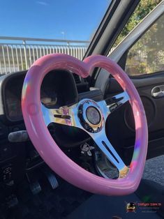 a pink steering wheel cover with a heart shaped design on the front and center console