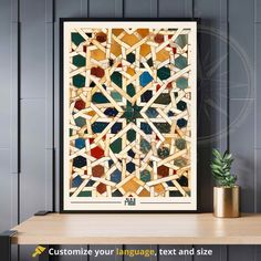 an art print with colorful stained glass and gold accents on a shelf next to a potted plant