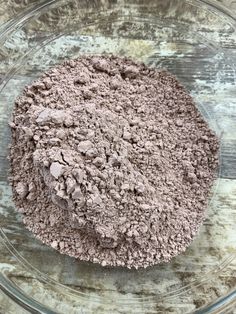 a bowl filled with dirt sitting on top of a wooden table