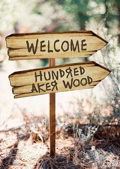 a wooden sign that says, welcome to hundreds are wood and has two arrows pointing in different directions