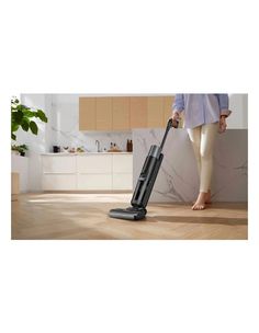 a woman is using a vacuum to clean the floor